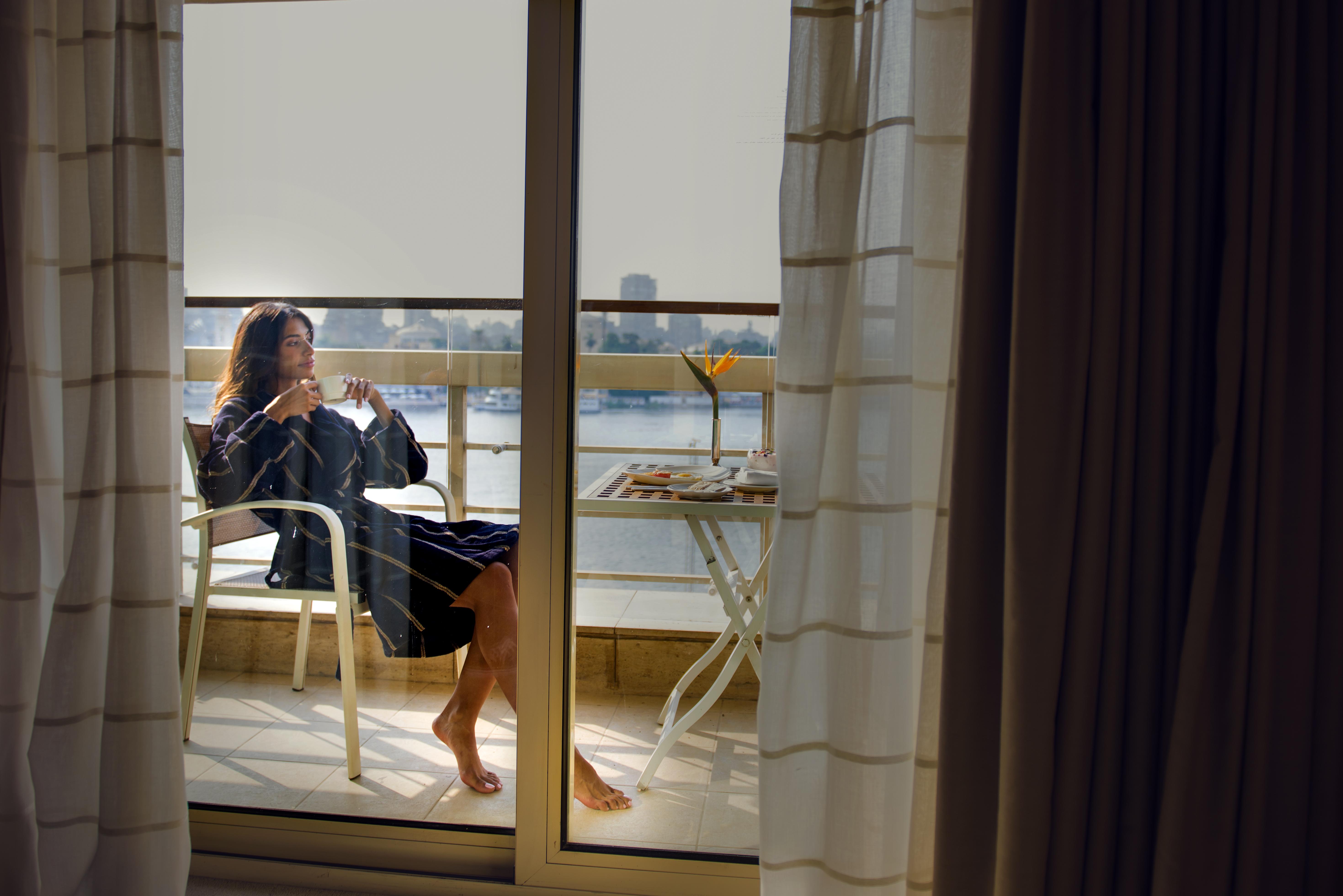 Kempinski Nile Hotel, Кайро Екстериор снимка A woman on a balcony
